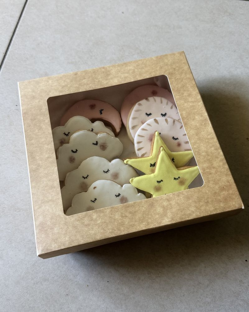 Boîte de biscuits sablés décorés en forme de nuages, d'étoiles, de lunes et de soleils aux visages endormis
