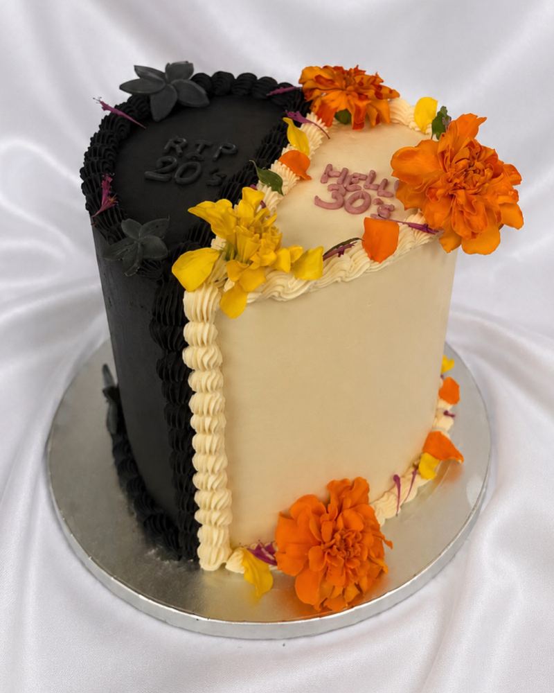 Gâteau d'anniversaire des 30 ans mi-noir mi-crème, décoré de fleurs orange et jaunes