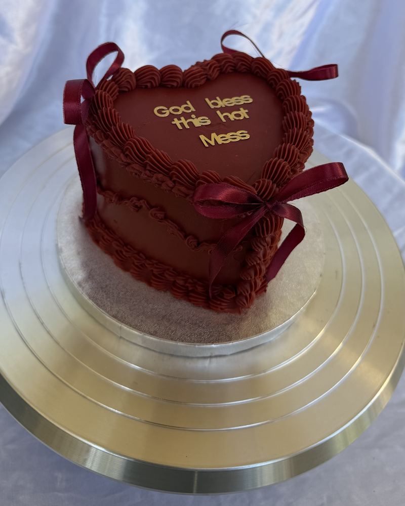 Gâteau cœur bordeaux avec rubans de satin et lettres dorées