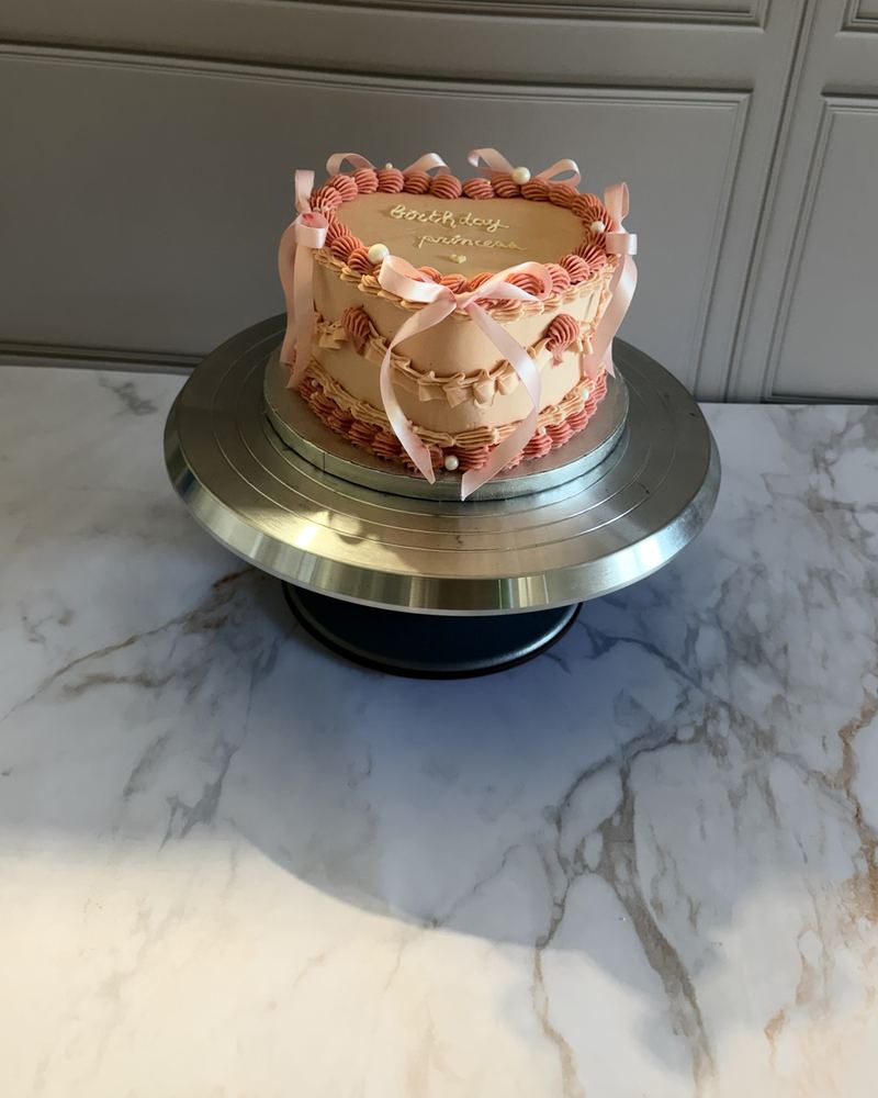 Gâteau cœur pêche et rose de style vintage avec nœuds de satin rose et inscription « Birthday princess »